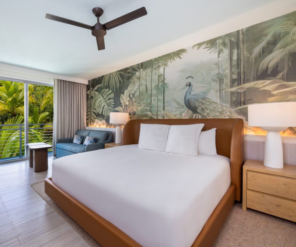 a king room at sls baha mar with tropical wallpaper and a leather king bed headboard