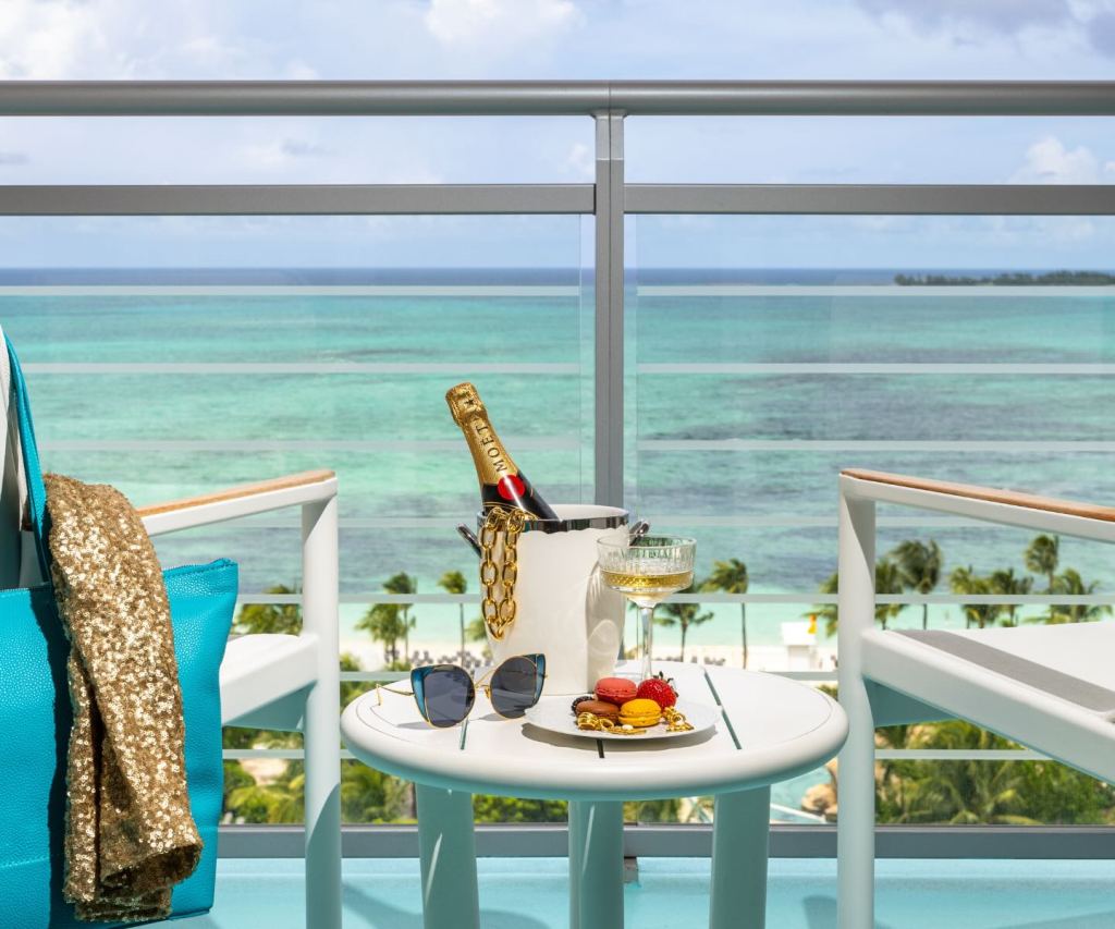 a view of the ocean from a terrace at a room at sls baha mar with a bottle of moet on ice on a side table