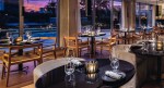 Um restaurante com mesas elegantemente postas para uma experiência de refeições deliciosa no Leynia Puerto Madero.