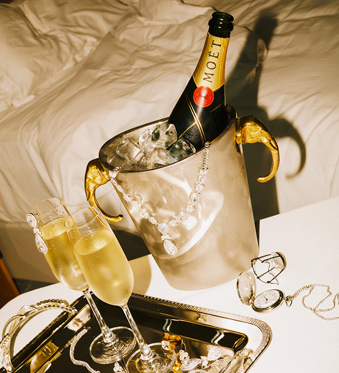 Bedside champagne in an ice bucket, with diamonds and jewelry scattered about