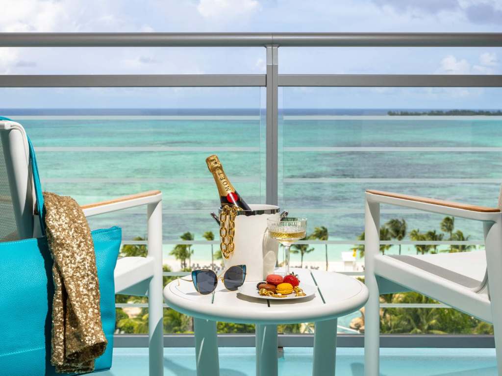 a view of the ocean from a terrace at a room at sls baha mar with a bottle of moet on ice on a side table