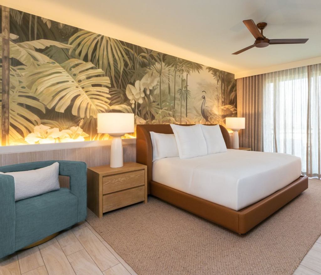 a superior king accessible room at sls baha mar with tropical wallpaper and a leather king bed headboard