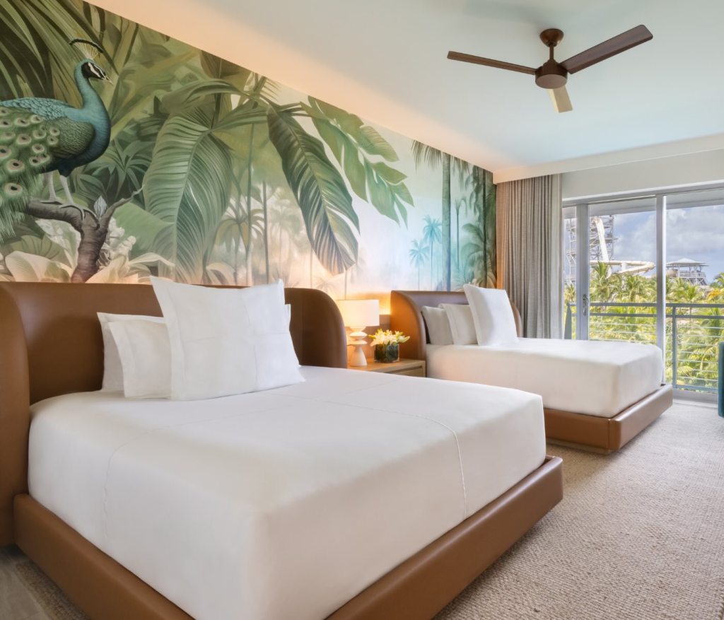 two queen beds in a room with tropical wallpaper