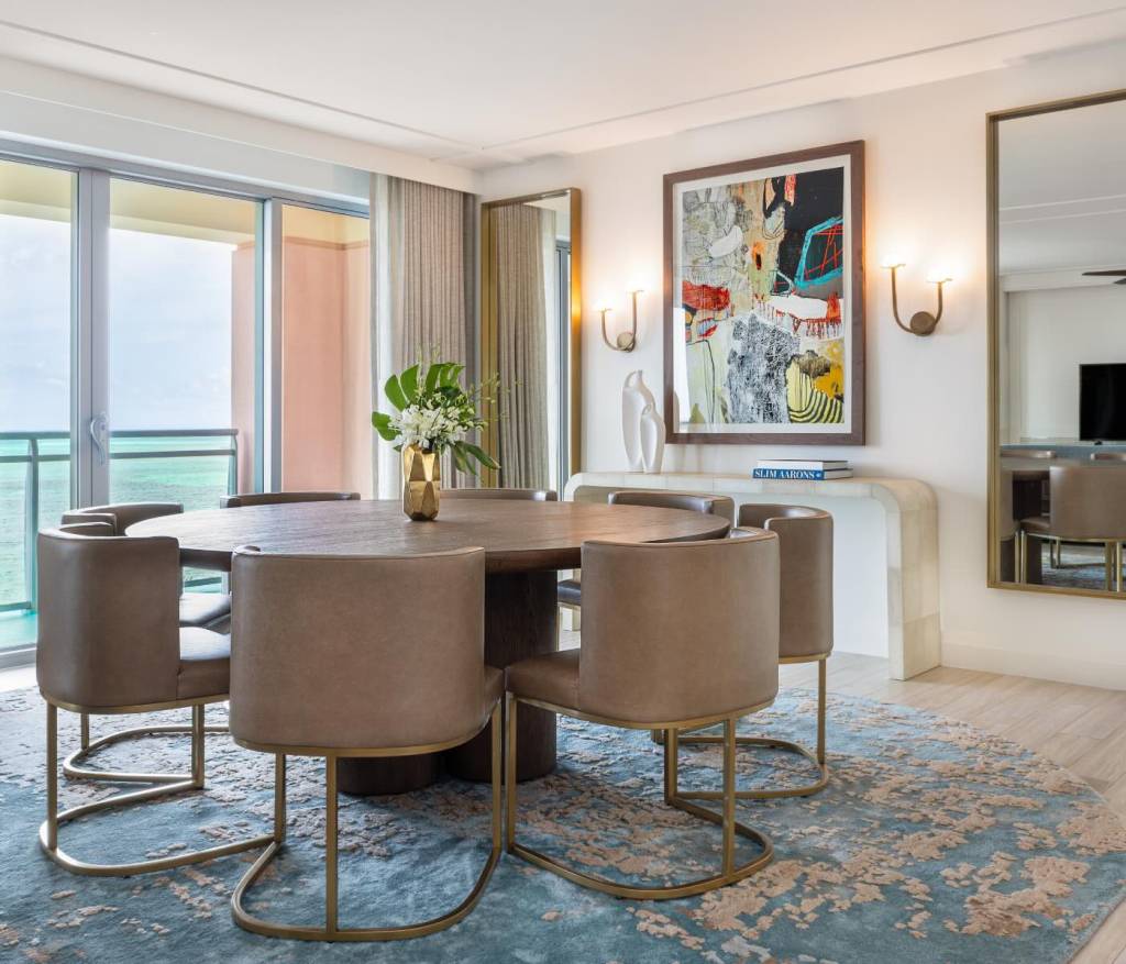 a circular dining table with leather chairs on top of a blue rug