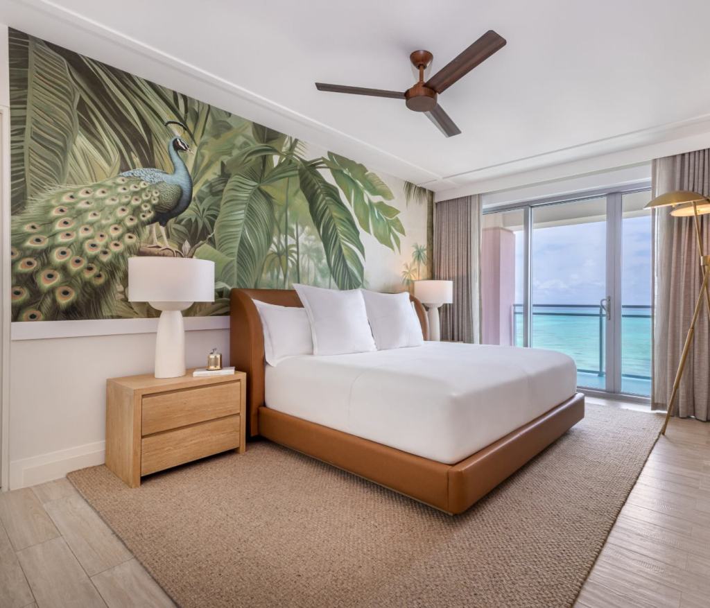 a king bed in a leather bed frame with tropical wallpaper 