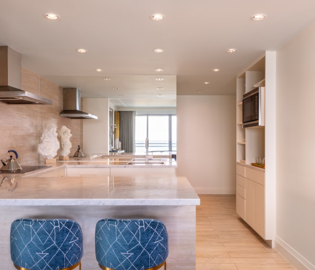 counter space with two stools looking into the kitchen