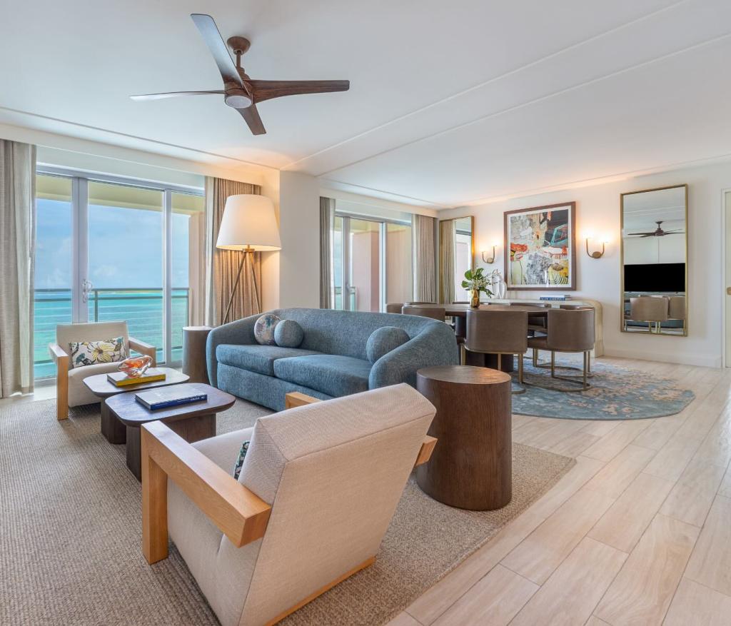 an expansive living space with a blue couch, white chairs and coffee table