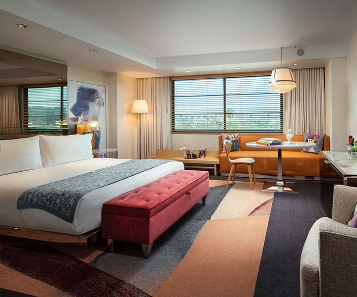 Lujosa habitación de hotel con una estilosa cama, un elegante sofá y una ventana. 