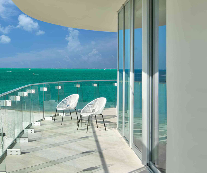 Exquisito balcón con dos elegantes sillas, que ofrece una impresionante vista del océano.