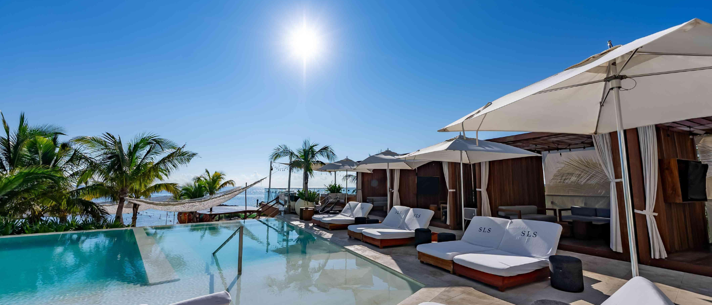 Piscina infinita con vistas a la playa y al agua.