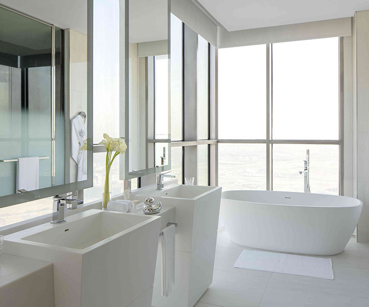 Elegant bathroom featuring a grand tub and expansive window with a beautiful view.