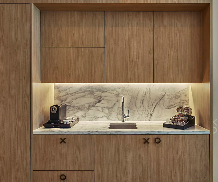 full minibar with wood cabinets and marble backsplash