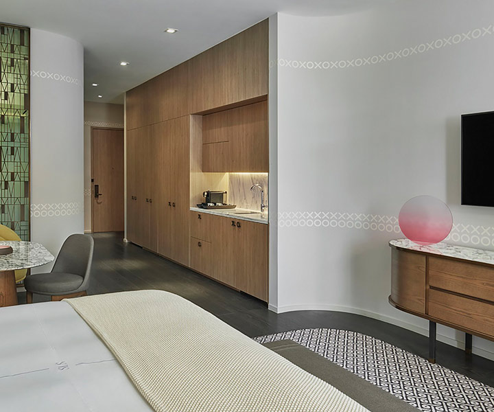 stylishly appointed room with mounted HDTV, and mini bar with a king bed