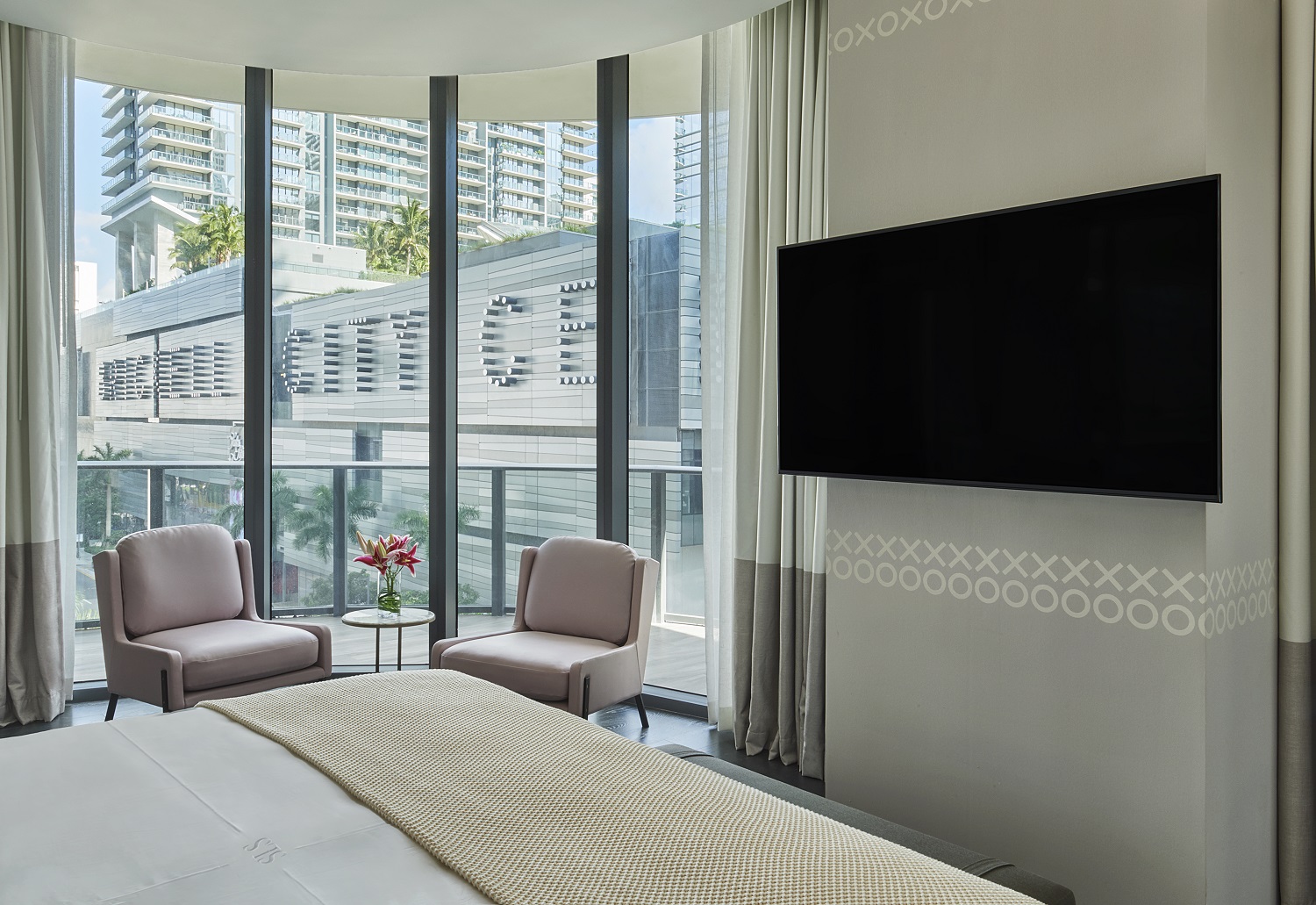 Lujosa habitación de hotel con cama king-size y elegante televisor de pantalla plana.