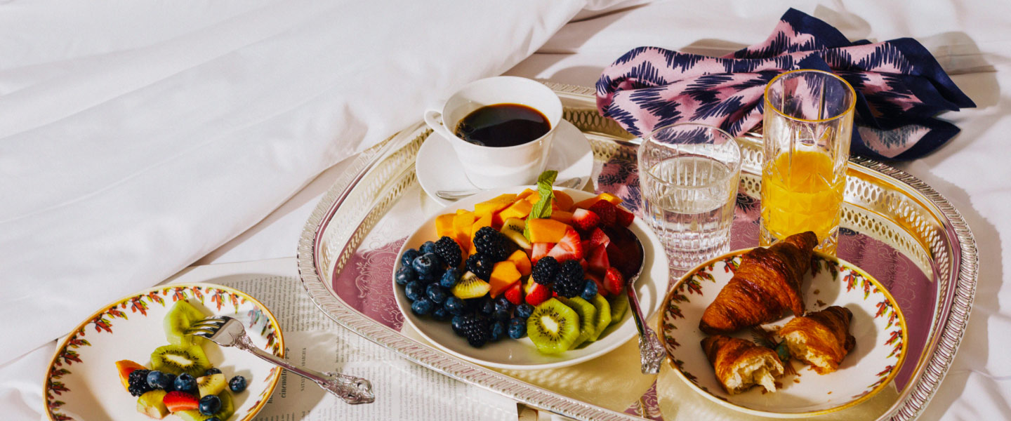 breakfast in bed with delicious spread of food and beverages