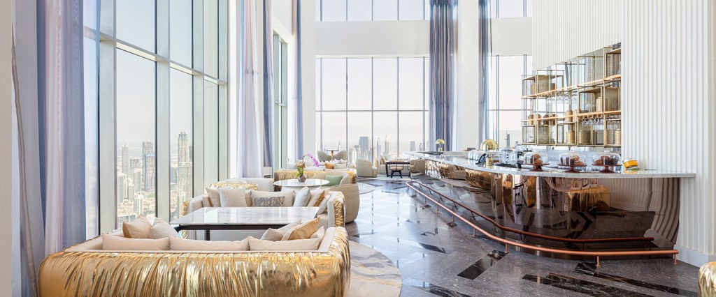 Um convidativo átrio do hotel, o S Bar at SLS Dubai, com mobiliário moderno e grandes janelas que oferecem uma vista panorâmica.