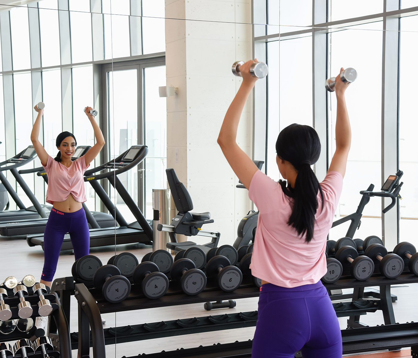 Woman lighting free weights in the gym