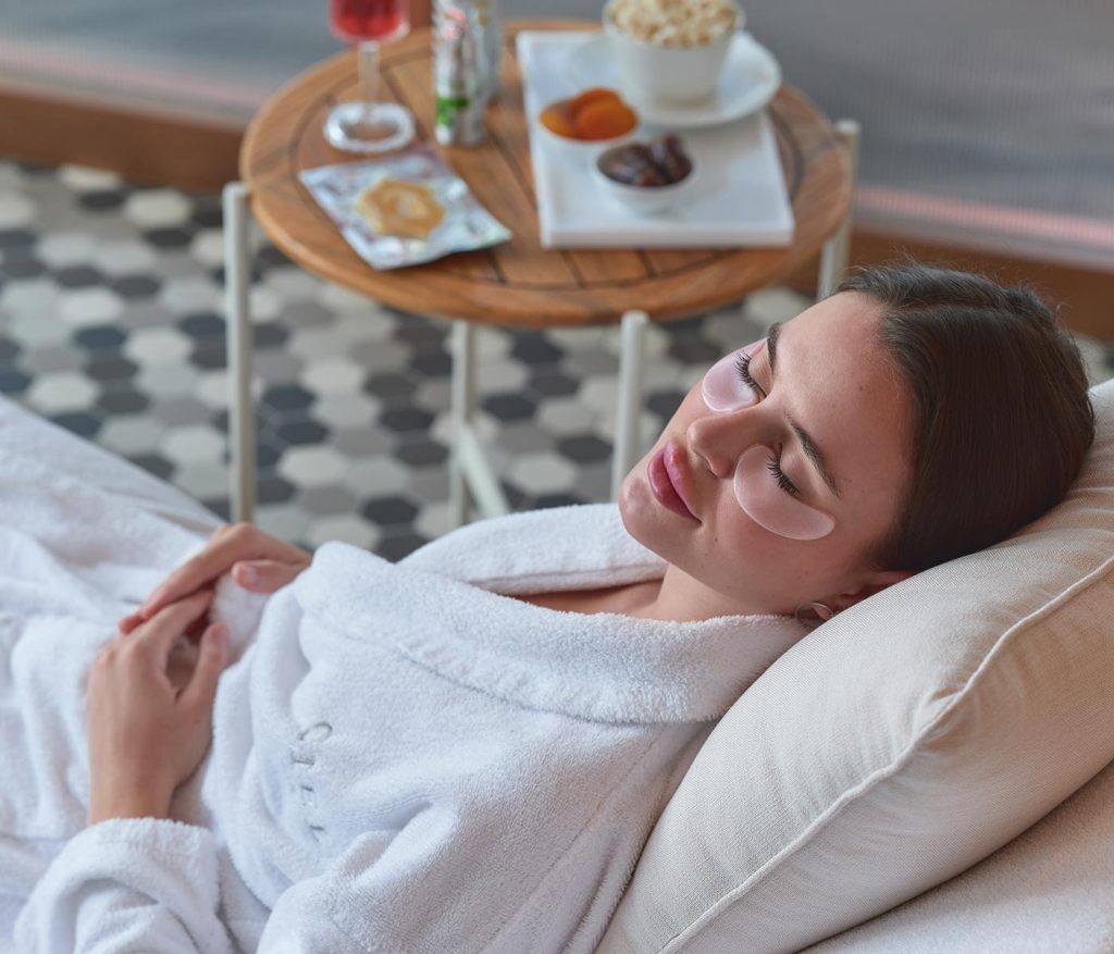 a woman in a spa relaxation room with white robe one