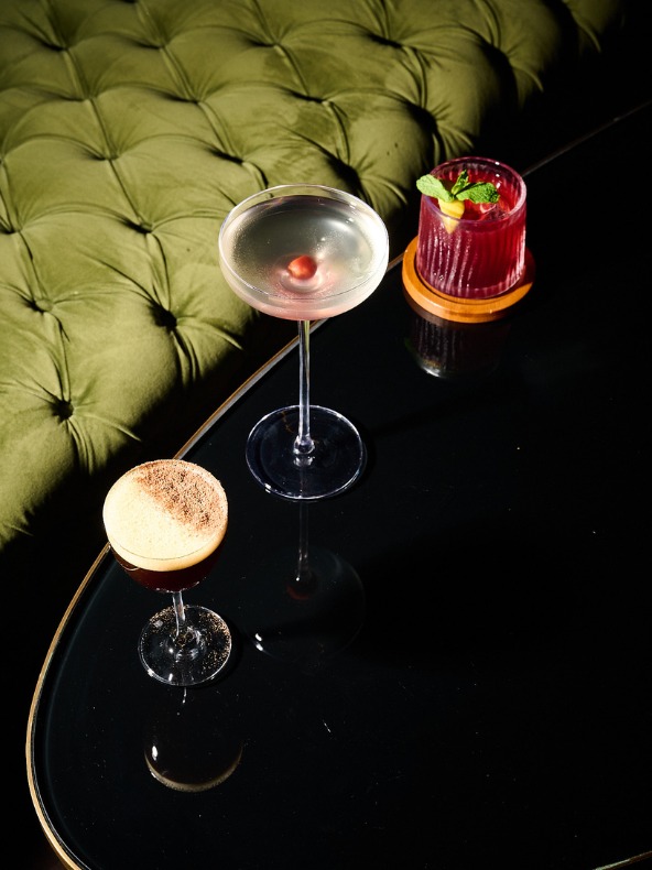 Images of three cocktails on a table next to a green couch