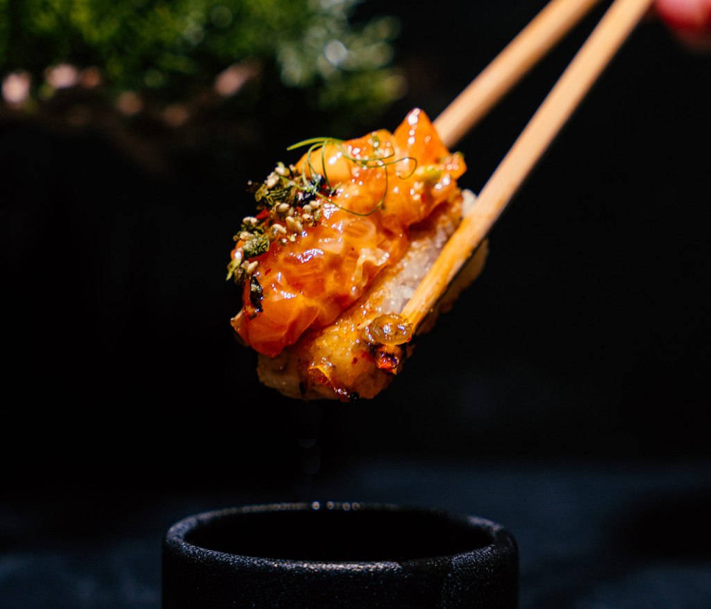 single piece of sushi on chopsticks