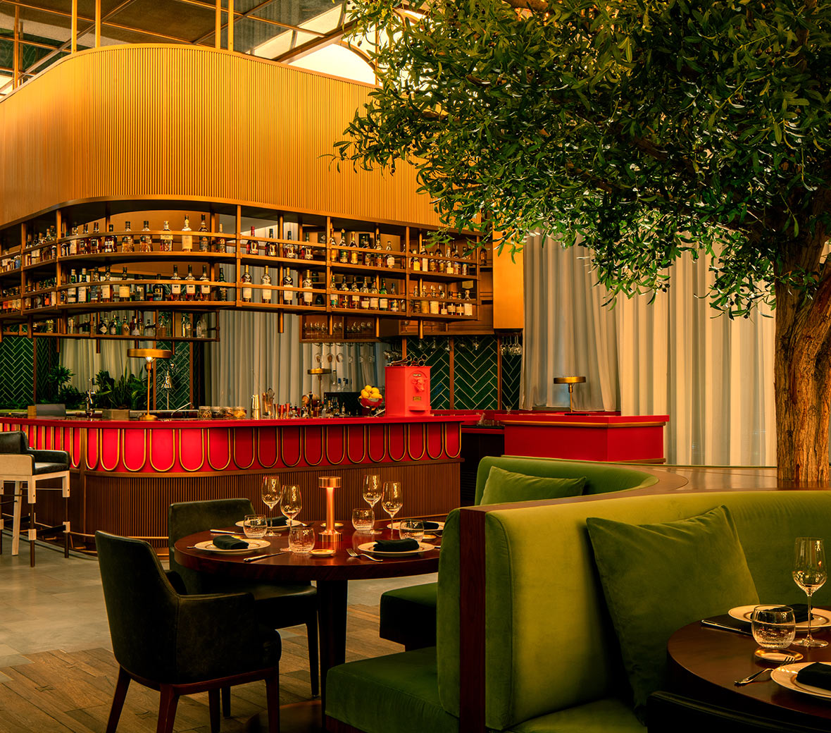 Carna, a restaurant at SLS Dubai with a central bar and tables in a spacious room, offering a cozy and inviting ambiance.