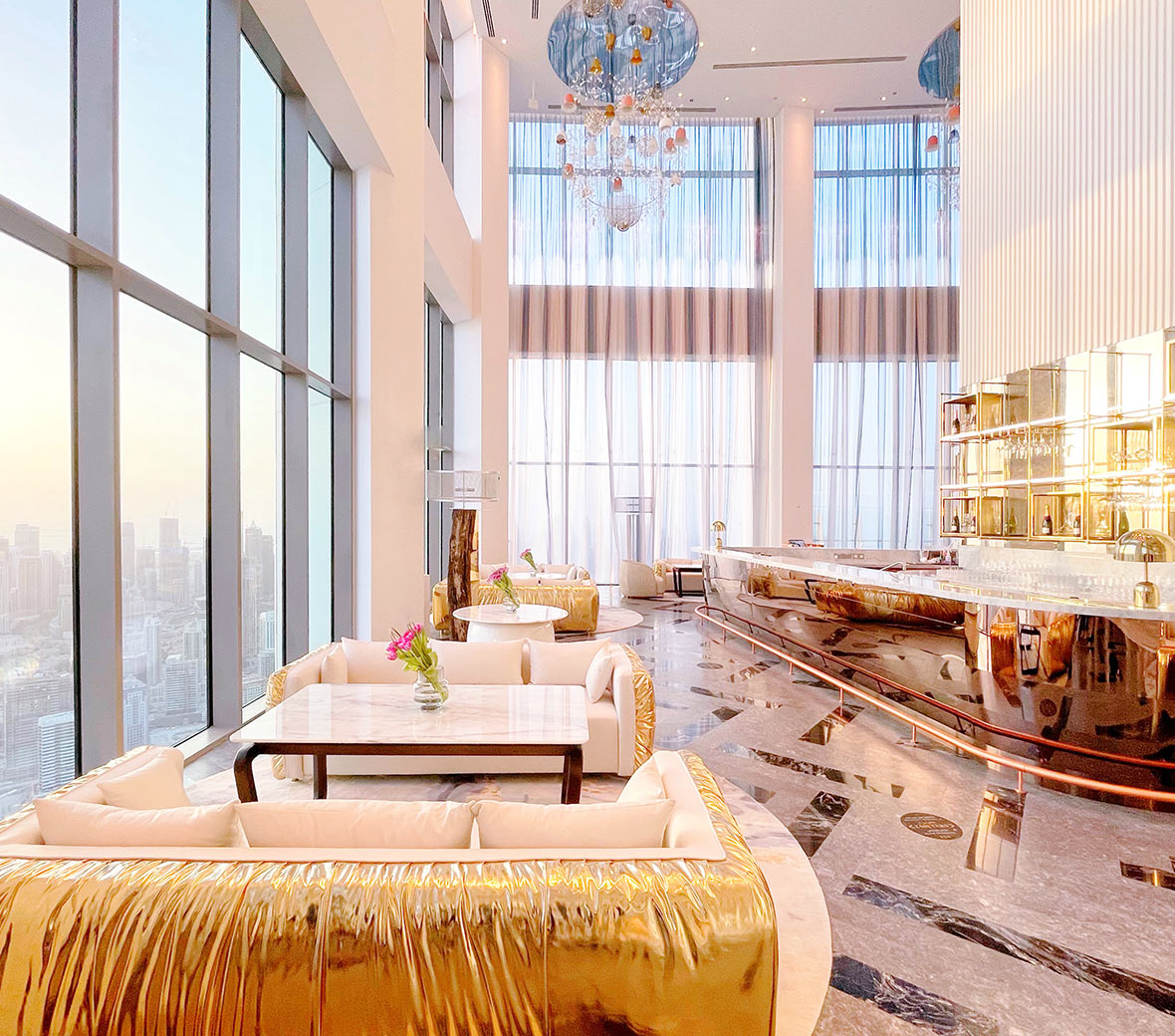 An inviting hotel lobby, S Bar at SLS Dubai, with modern furnishings, and large windows offering a scenic view.