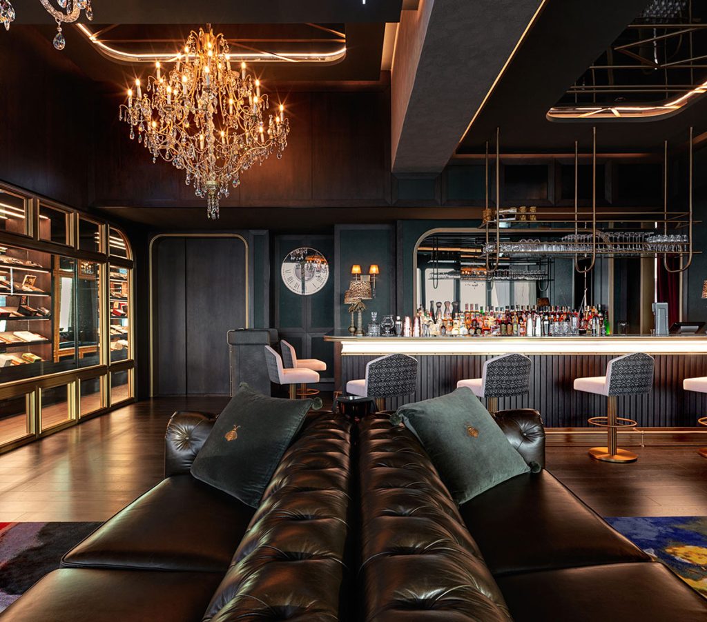 Smoke & Mirrors en SLS Dubai, un bar con elegantes muebles de cuero negro, una llamativa lámpara de araña y un humidor de puros.