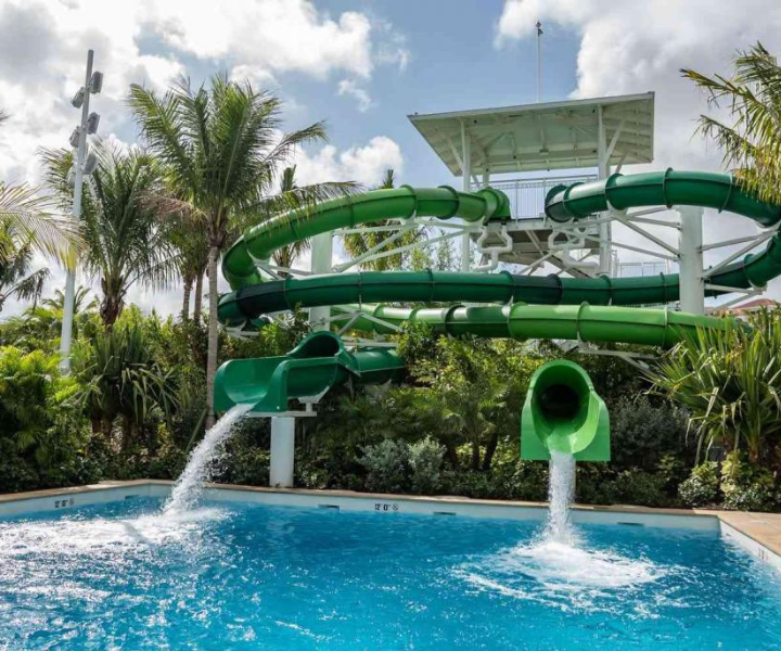 the exit of two green waterslides into a deep pool