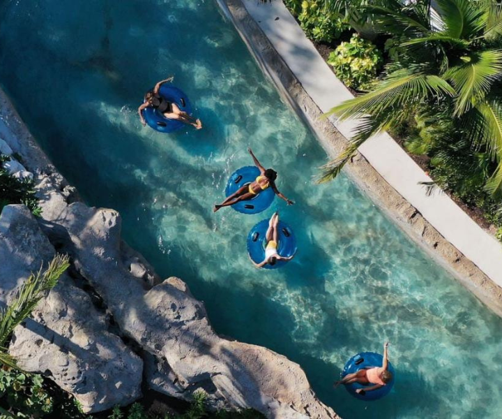 Un río lento de diseño natural rodeado de palmeras