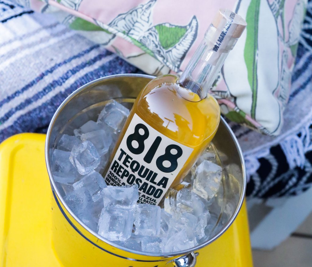 one bottle of 818 tequila in a silver bucket of ice