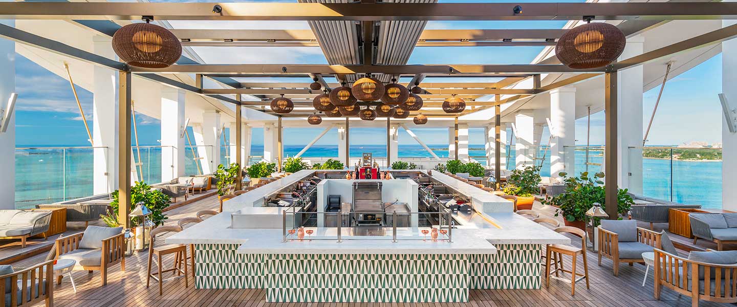 Image of Skybar, rooftop bar at SLS Baha Mar, with ample seating and a bar overlooking the ocean.