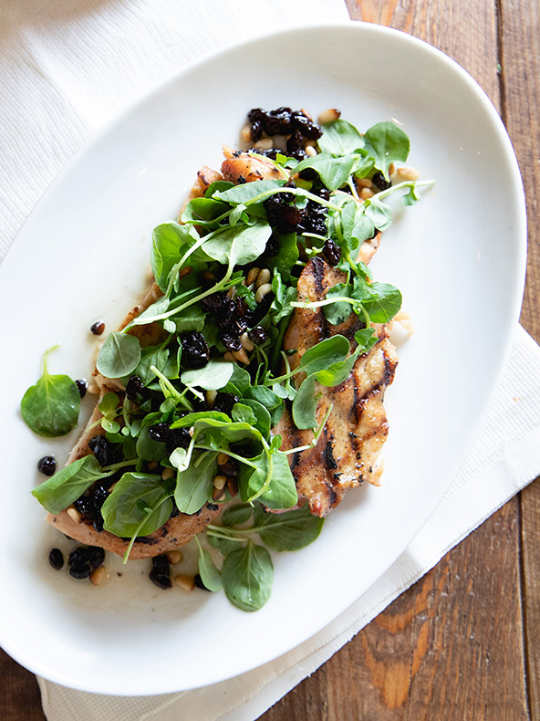 Une assiette de nourriture sur une table : un délicieux repas composé d’une viande et d’une garniture soigneusement disposées sur une assiette.