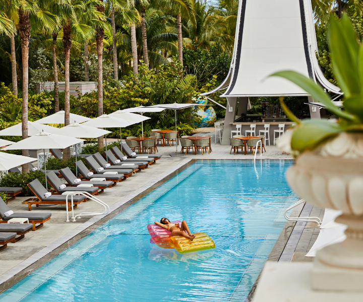 a woman floating in the pool on a colorful floatie