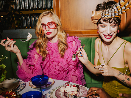 Mujeres estilosas sentadas a una mesa, disfrutando de deliciosa comida