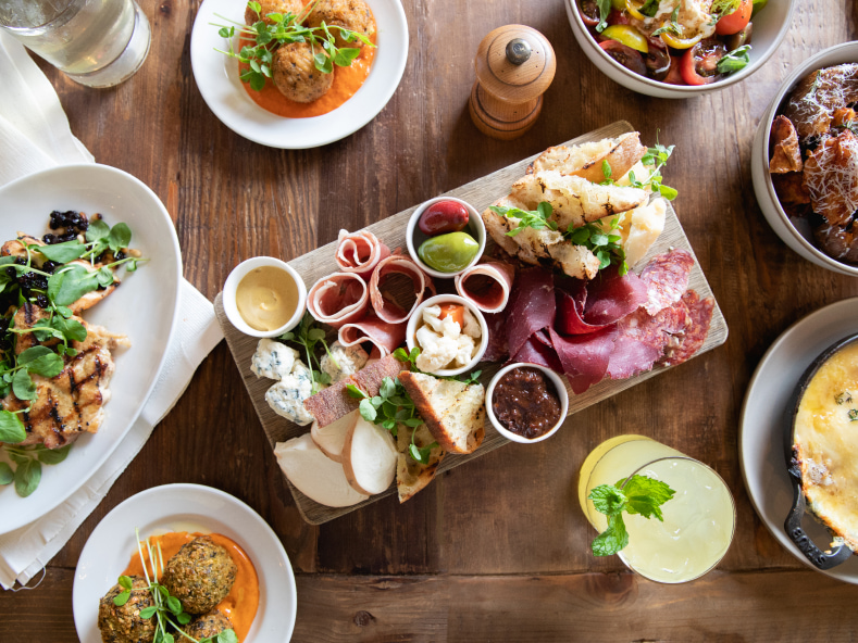 Uma mesa com uma travessa de comida deliciosa e bebidas refrescantes.