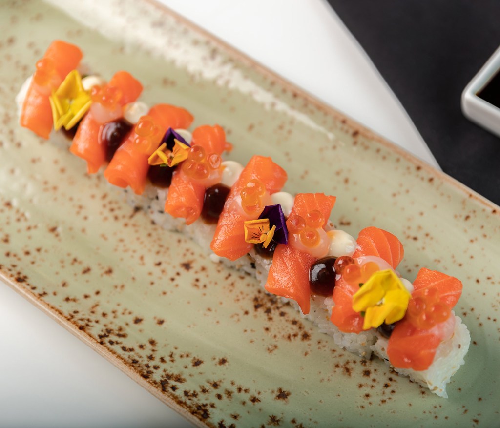 a platter of tuna Sushi, decorated with flowers