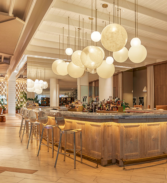 A spacious bar adorned with numerous hanging lights illuminating the area.