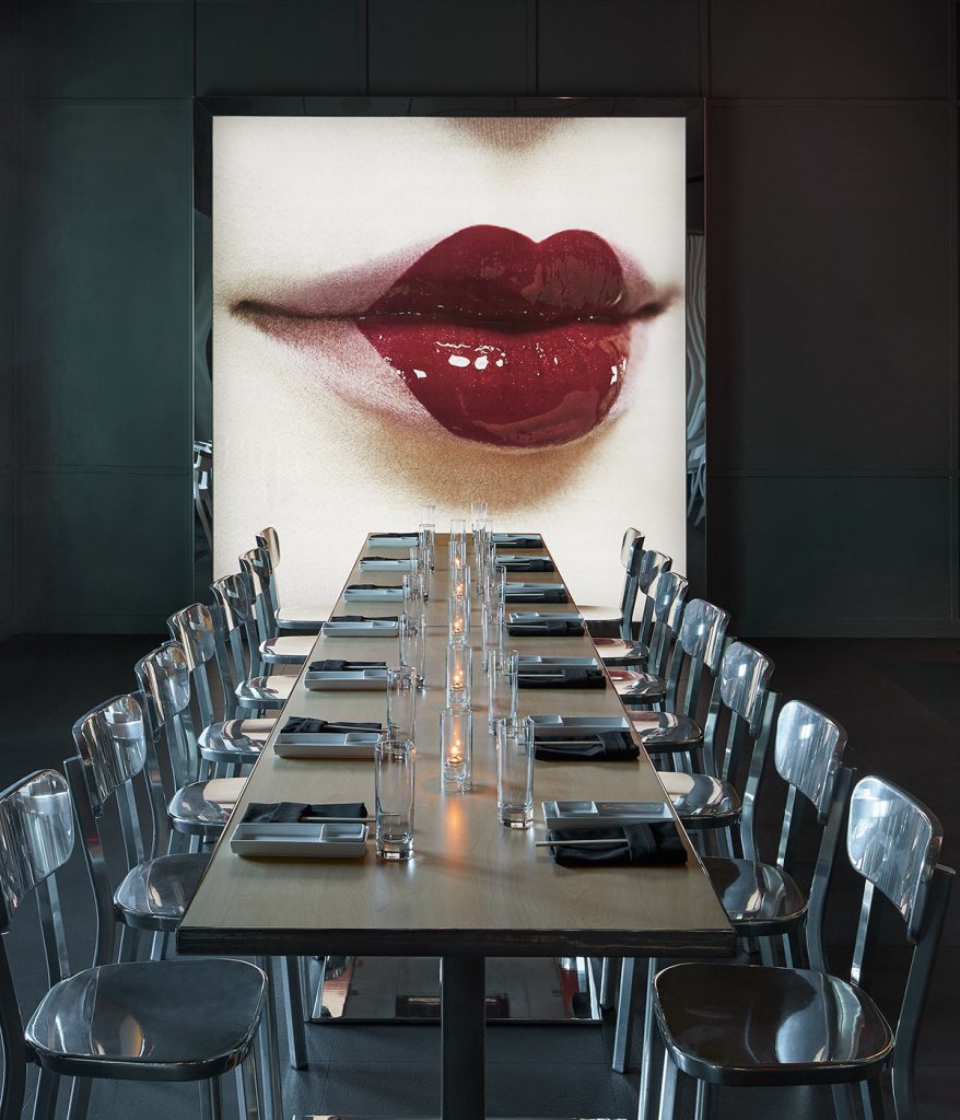 Comedor interior de Katsuya en SLS Baha Mar con imagen de labios rojos en el fondo