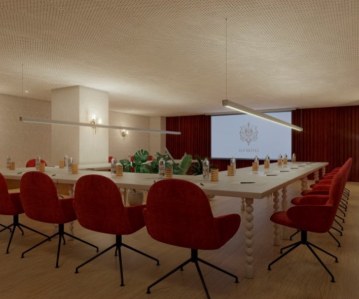 a meeting space set up in a classroom with orange chairs a screen