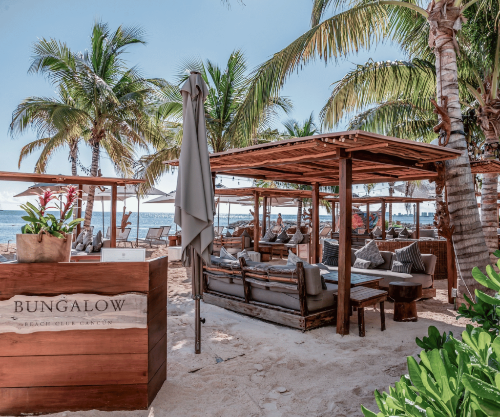 Luxurious beach restaurant with elegant chairs and stylish umbrellas on golden sand.