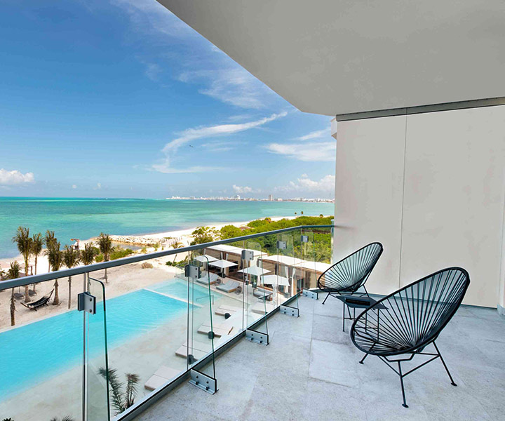 Elegant balcony with two chairs, offering a mesmerizing view of the beach's serene beauty.