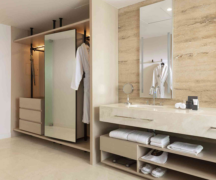 A lavishly adorned bathroom featuring a pristine sink, an elegant mirror, and a spacious walk-in closet.