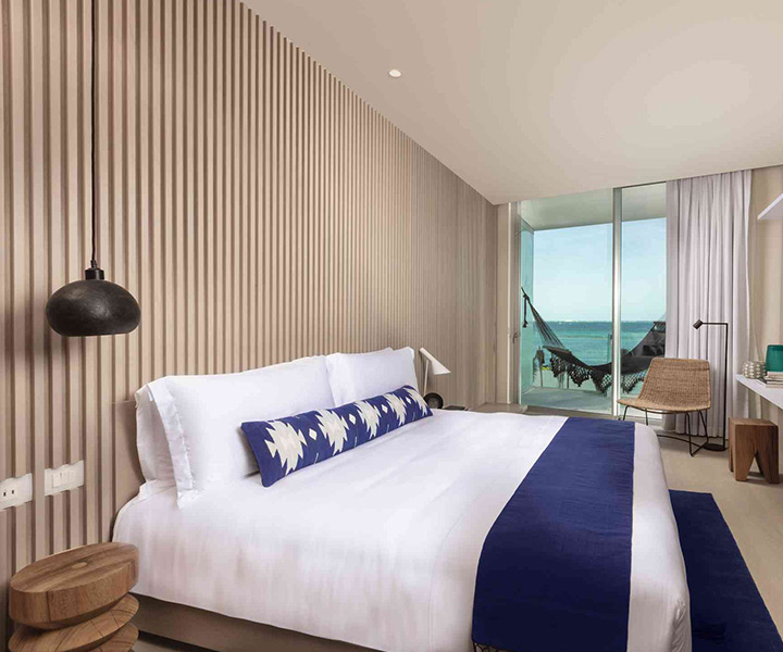 Luxurious hotel room with a plush bed, elegant desk, and breathtaking ocean view.