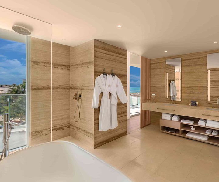 A lavish bathroom featuring a pristine bathtub, offering a breathtaking view of the ocean.
