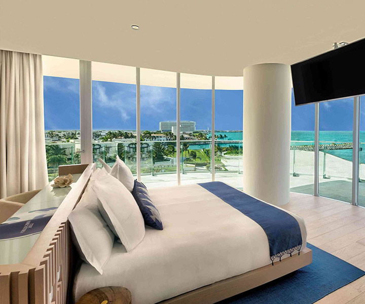 Luxurious bedroom with king-sized bed, offering stunning ocean views.