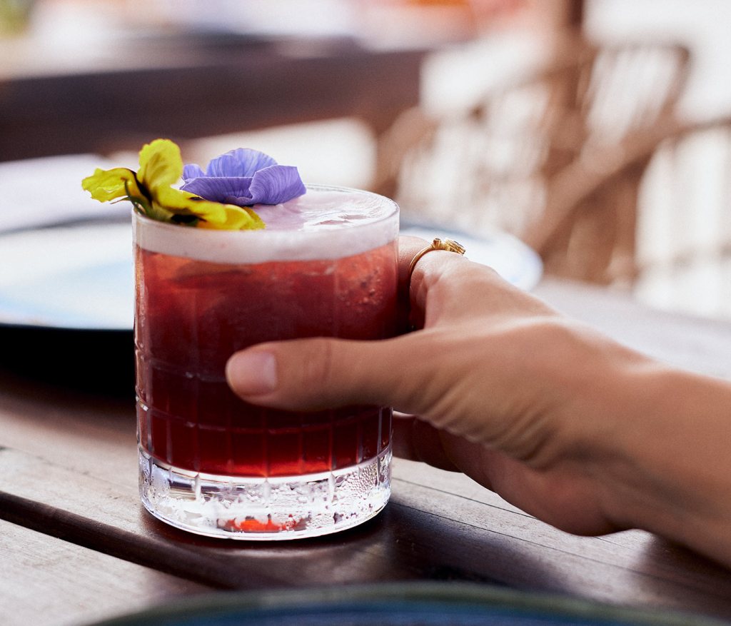 Red cocktail topped with flowers at SLS Cancun