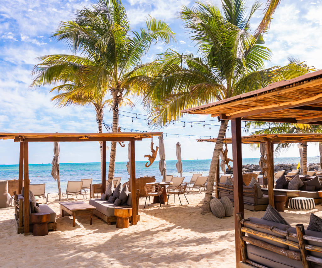 Comedor en la playa con hermosas cabañas y palmeras