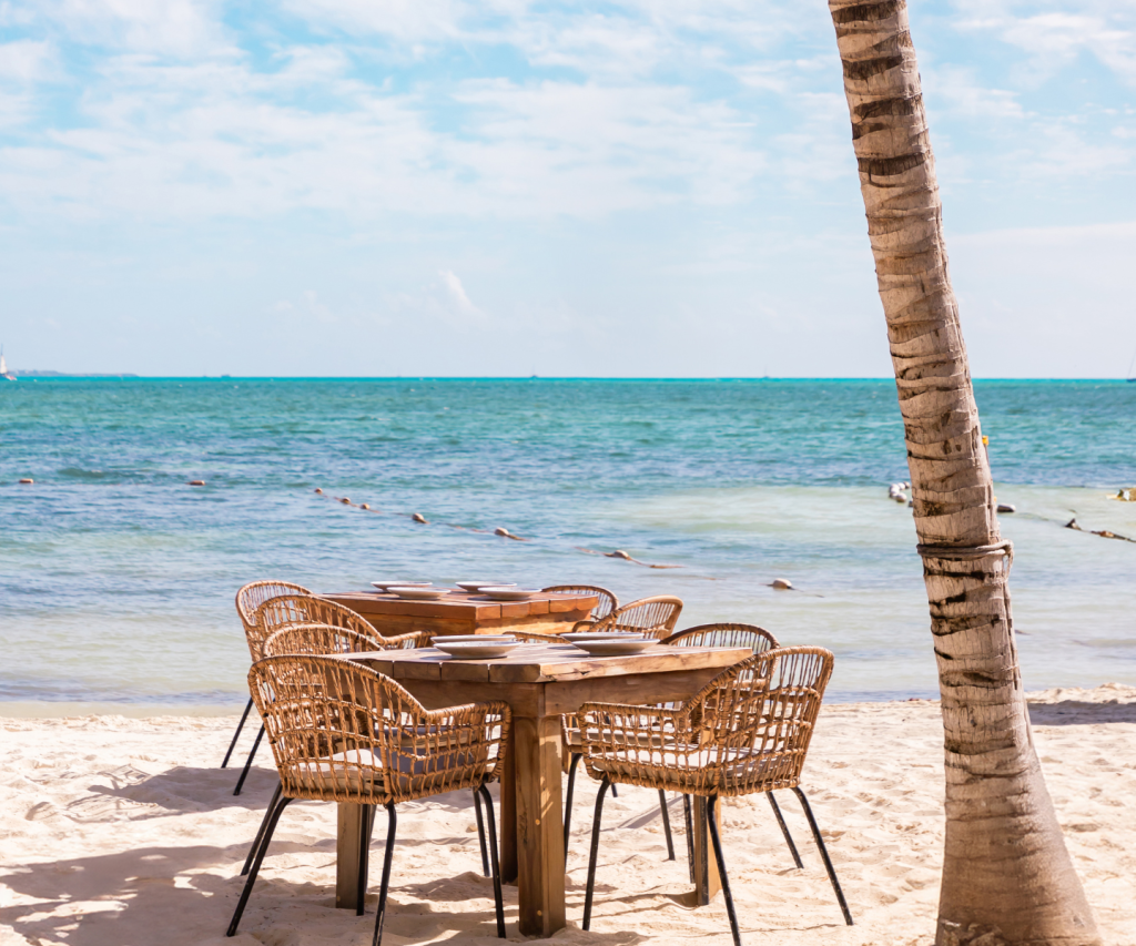 uma mesa na praia com vista para a água azul