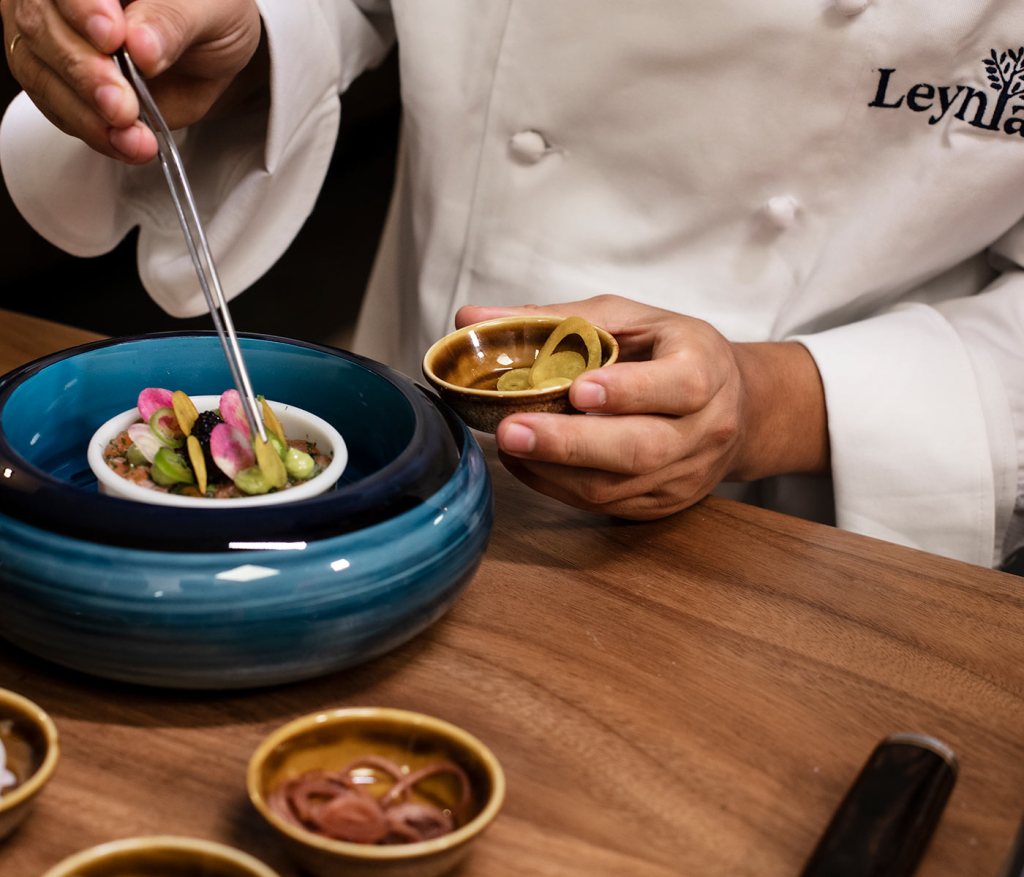 Chef of Leynia Cancun putting the finishing touches on ceviche with tweezers