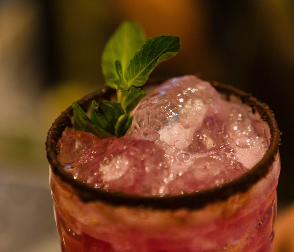 a cocktail served at cleo cancun with a mint garnish